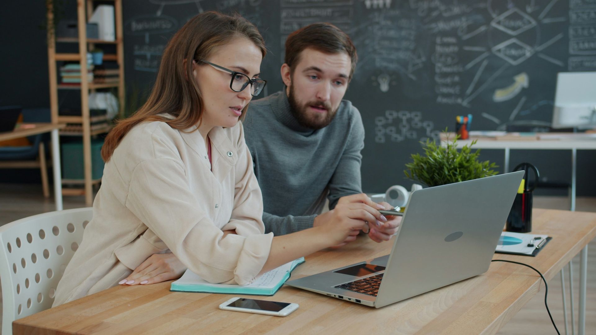Two colleagues collaborating on a project at a laptop
