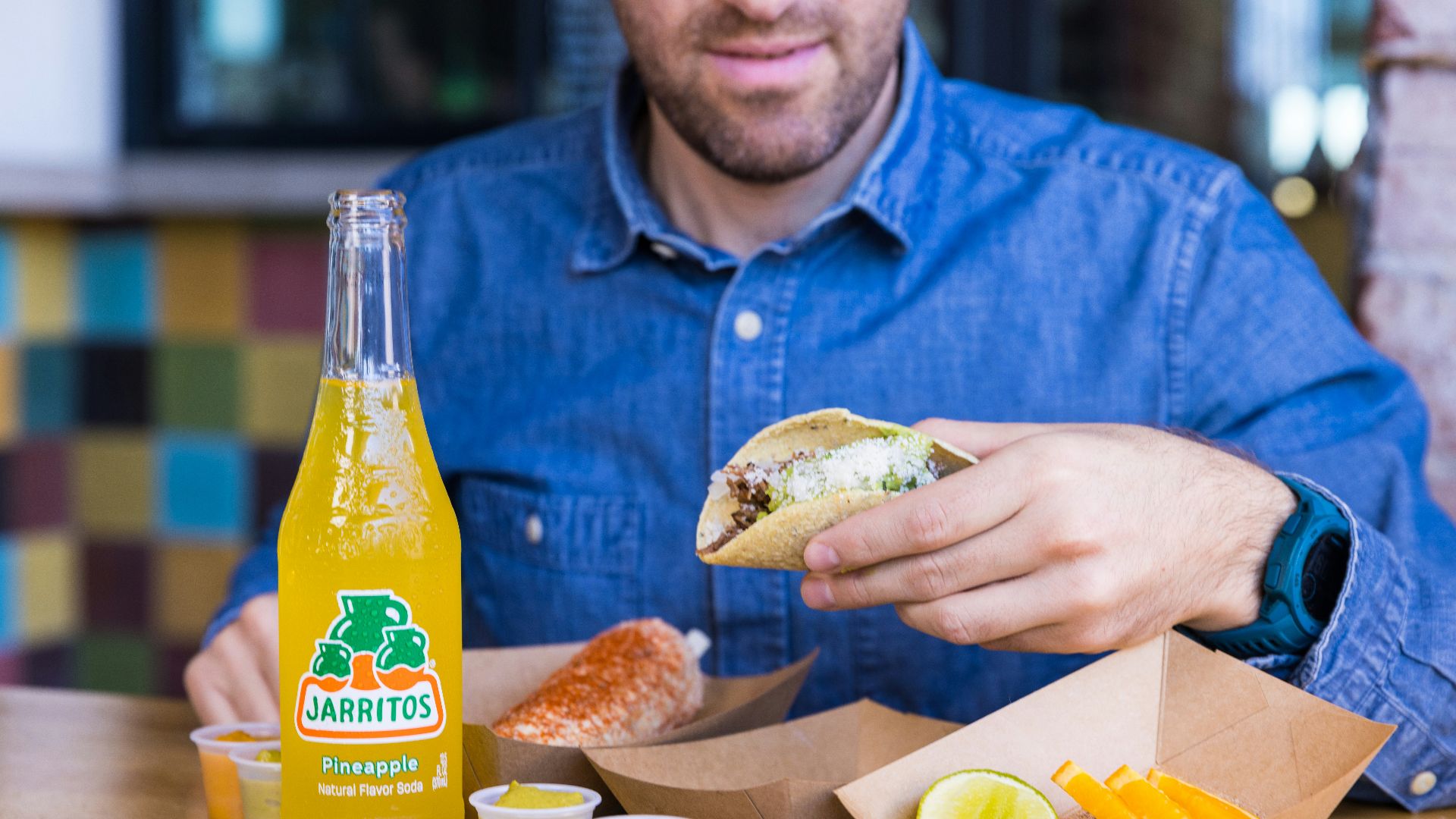 a man sitting at a table eating a sandwich