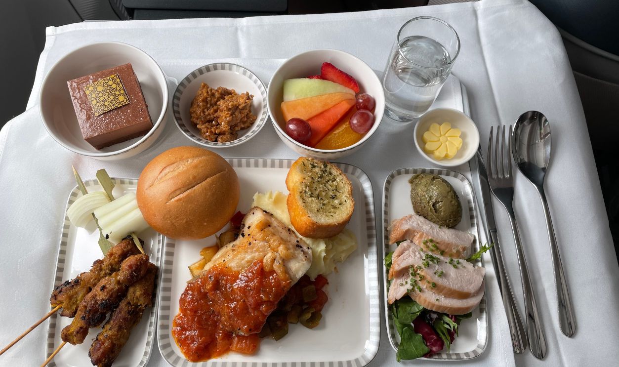 Gourmet Airline Meal with Assorted Dishes and Fresh Fruits