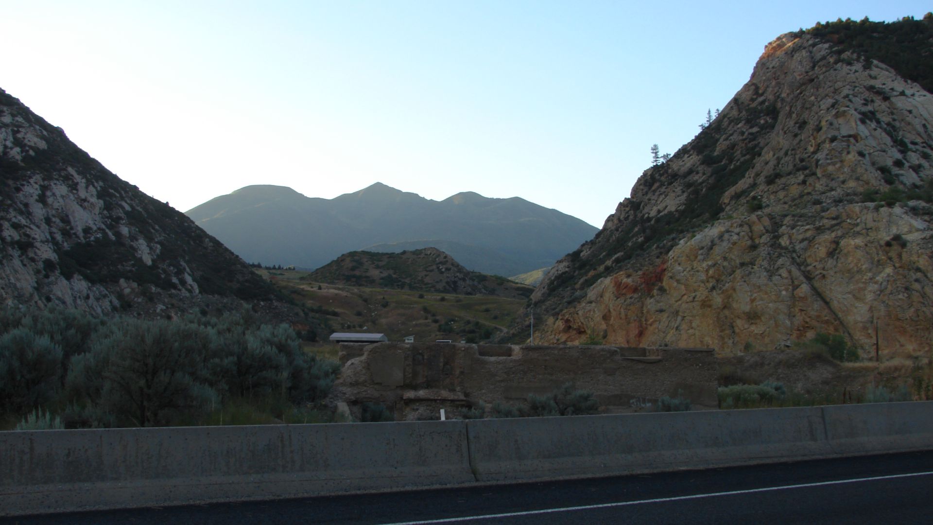 Looking north across US-89 at what is left of the former Thistle School in the ghost town of Thistle, Utah with the Thistle Gun Range and Thistle Slide Dam in the background, July 2015.