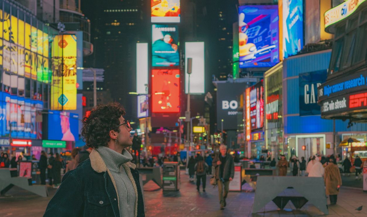 Explore the bustling energy of Times Square at night with vibrant lights and diverse crowds