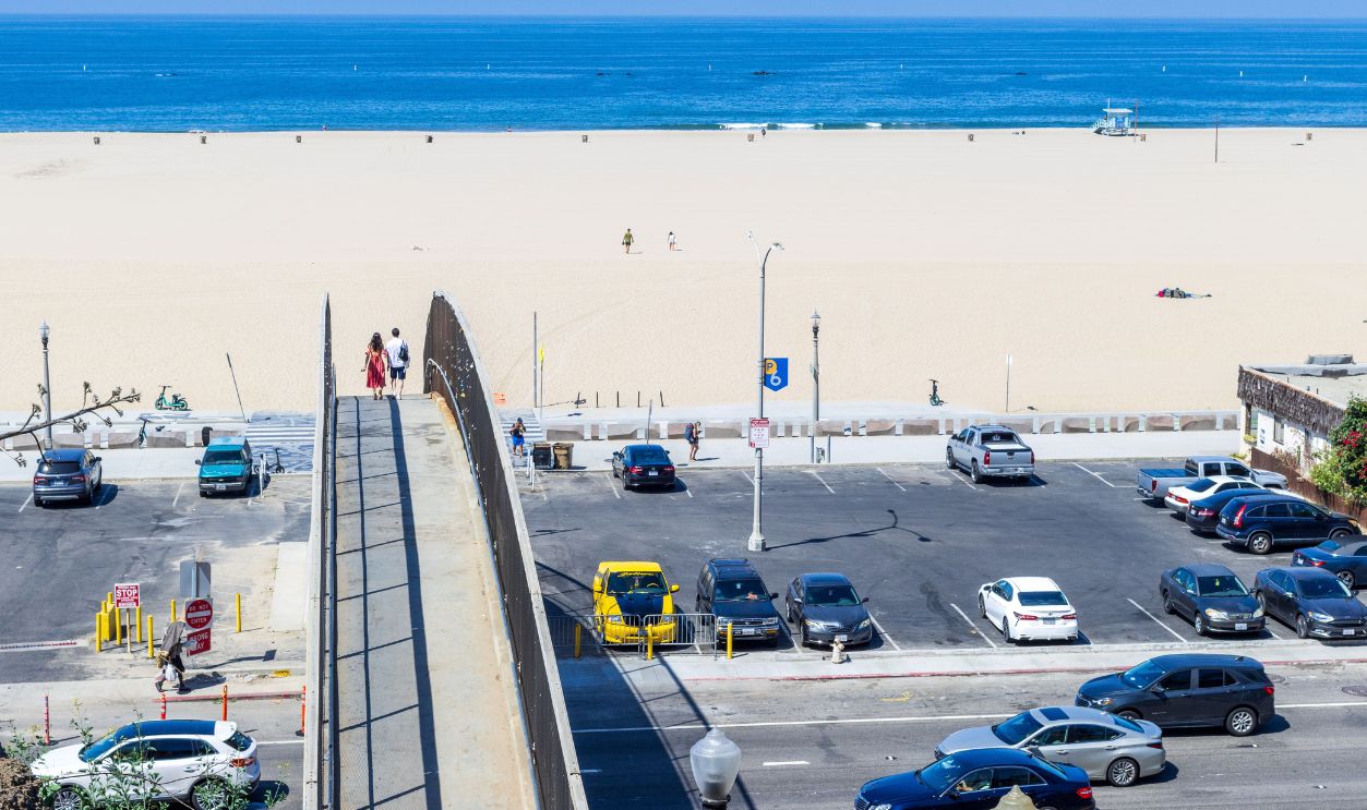 Aerial view of a coastal parking lot with footbridge 