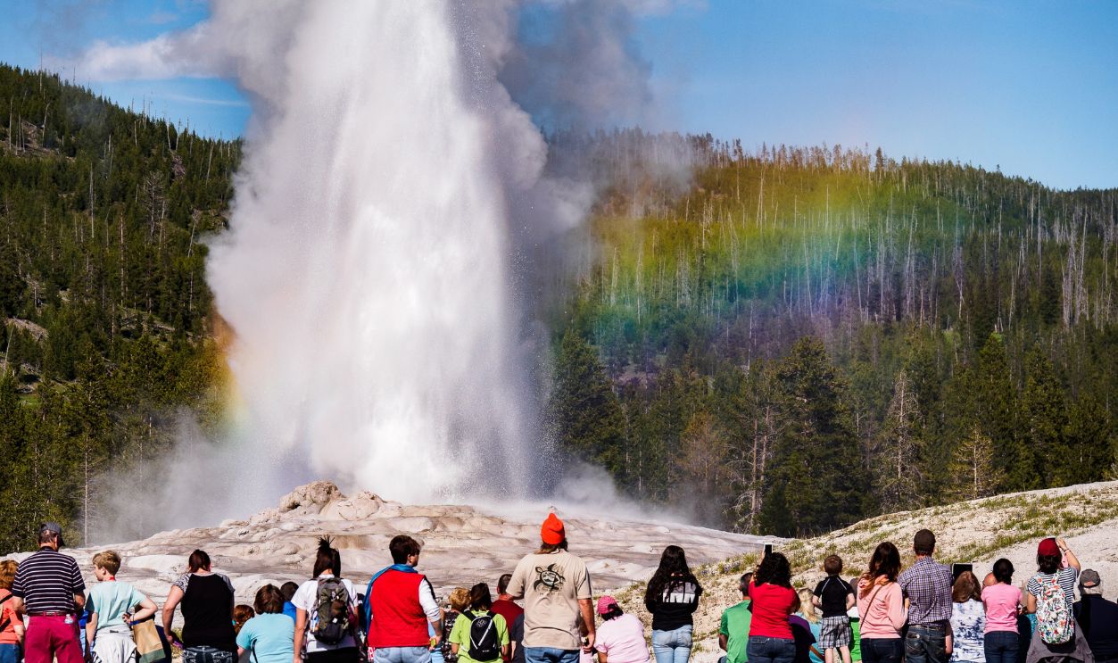 Tourists Watching Old Faithful Erupt in Yellowstone National Park
