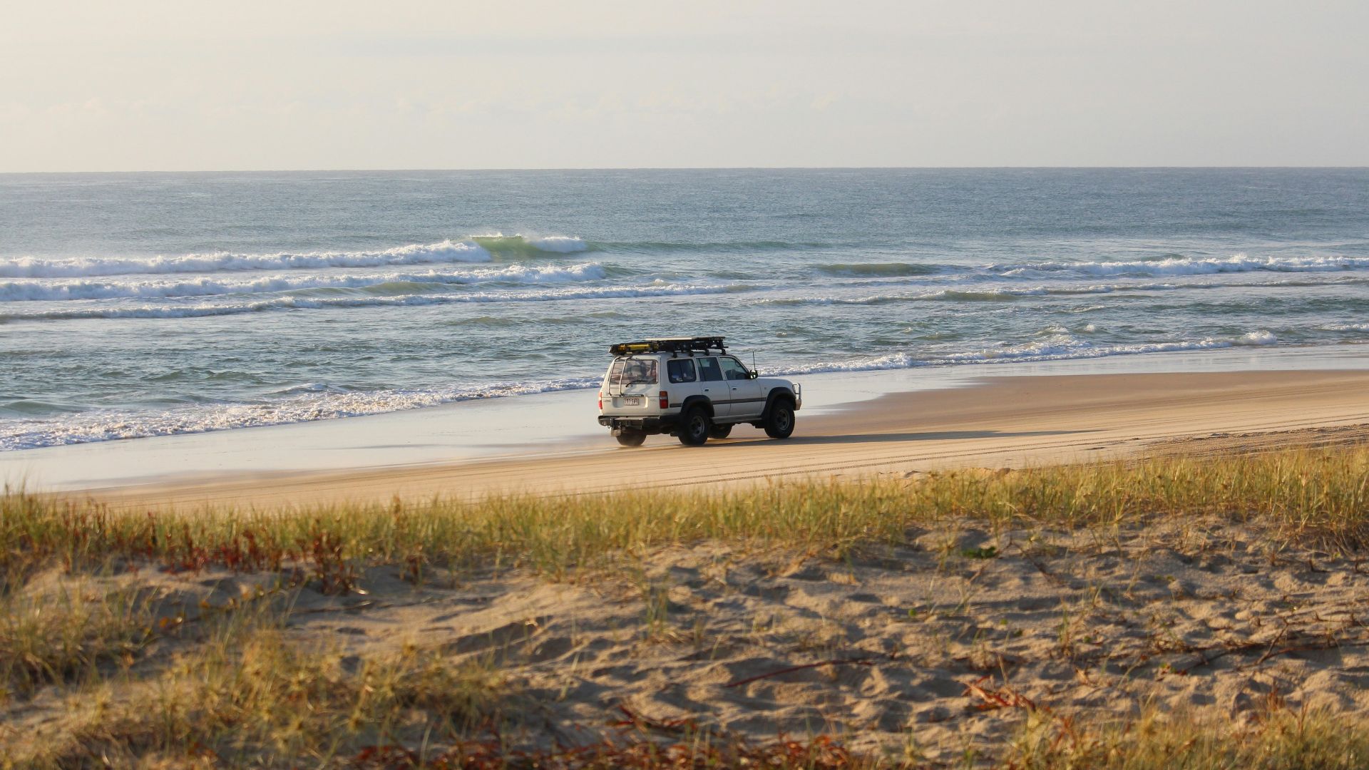 white vehicle beside seashore during daytime