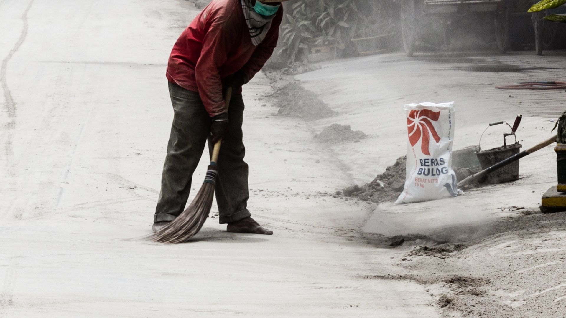 A man sweeping ash from the road during the 2014 eruption of Kelud.