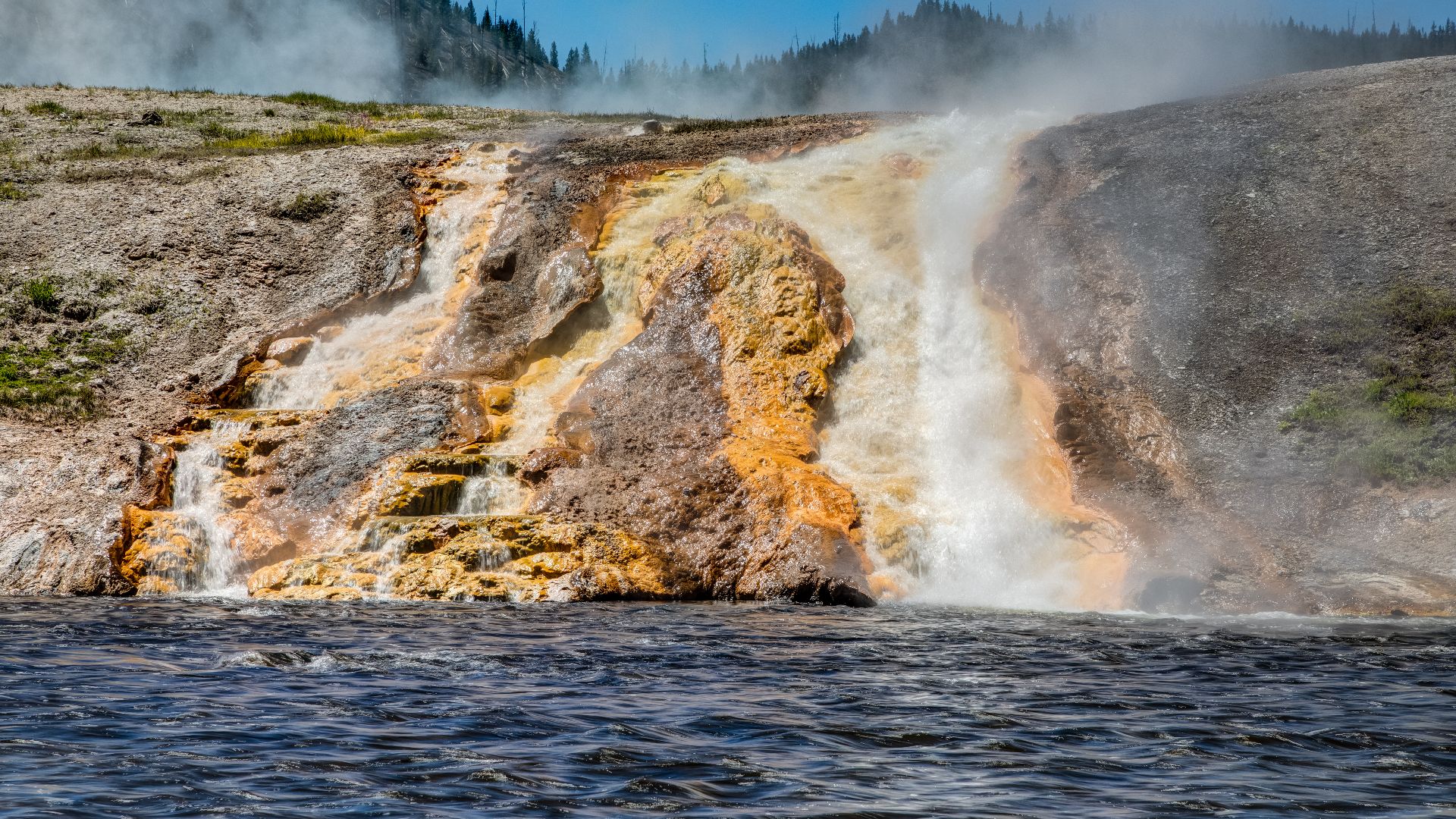 Hot waterfalls in the runoff channels of Excelsior Geyser into the Firehole River in Yellowstone National Park, Wyoming, USAYellowstone National Park was founded on March 1, 1872, and is considered the world’s first national park. It is located primarily 