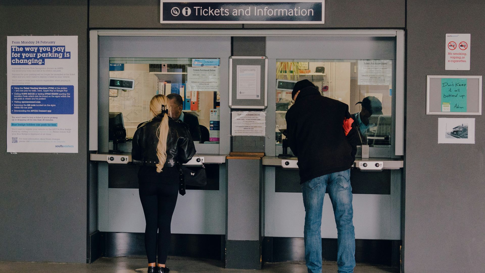 People are buying tickets at a ticket booth