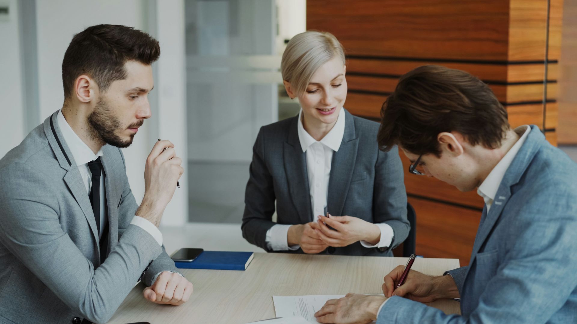 Business people signing a contract at a table