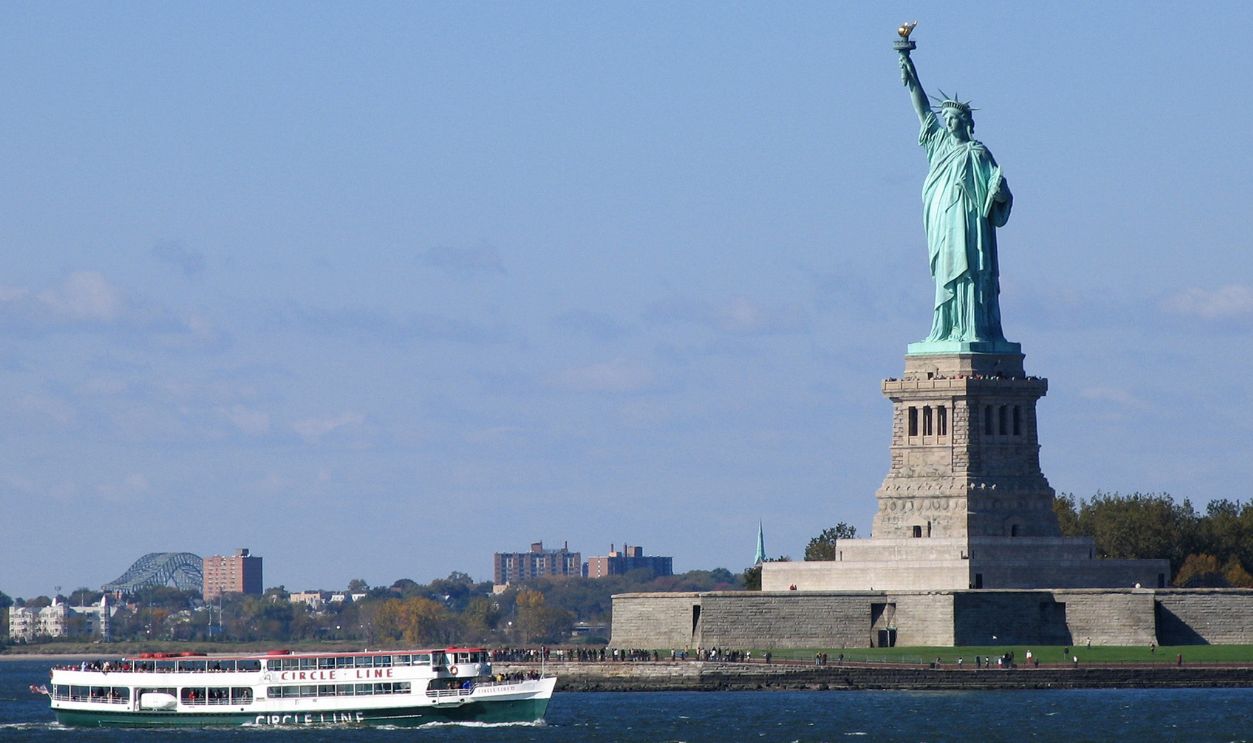 View of the Statue of Liberty with a ferry boat in New York City. Iconic American landmark