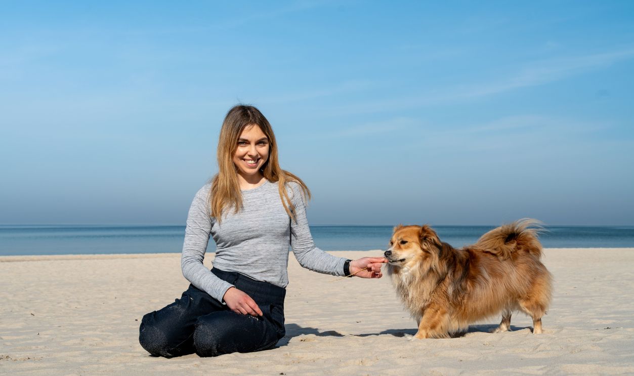 Woman enjoying a sunny day with her dog at Kołobrzeg beach
