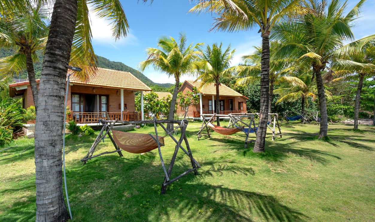 Tranquil tropical resort featuring palm trees, hammocks, and cozy bungalows under a bright summer sky