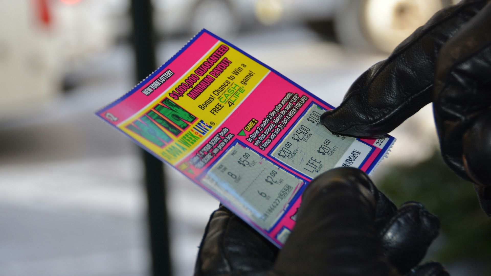 a person in black gloves holding a ticket