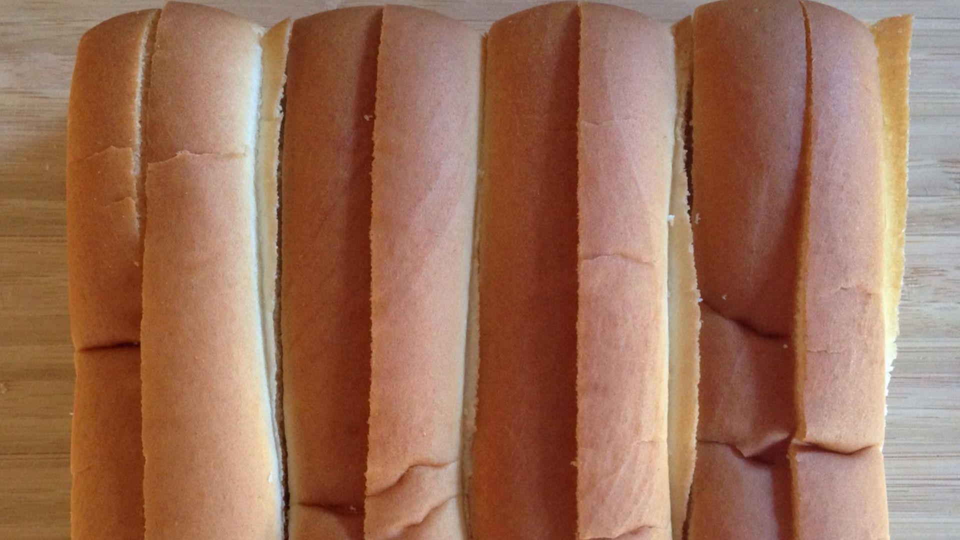 A top-down image of four New England-style hot dog buns.