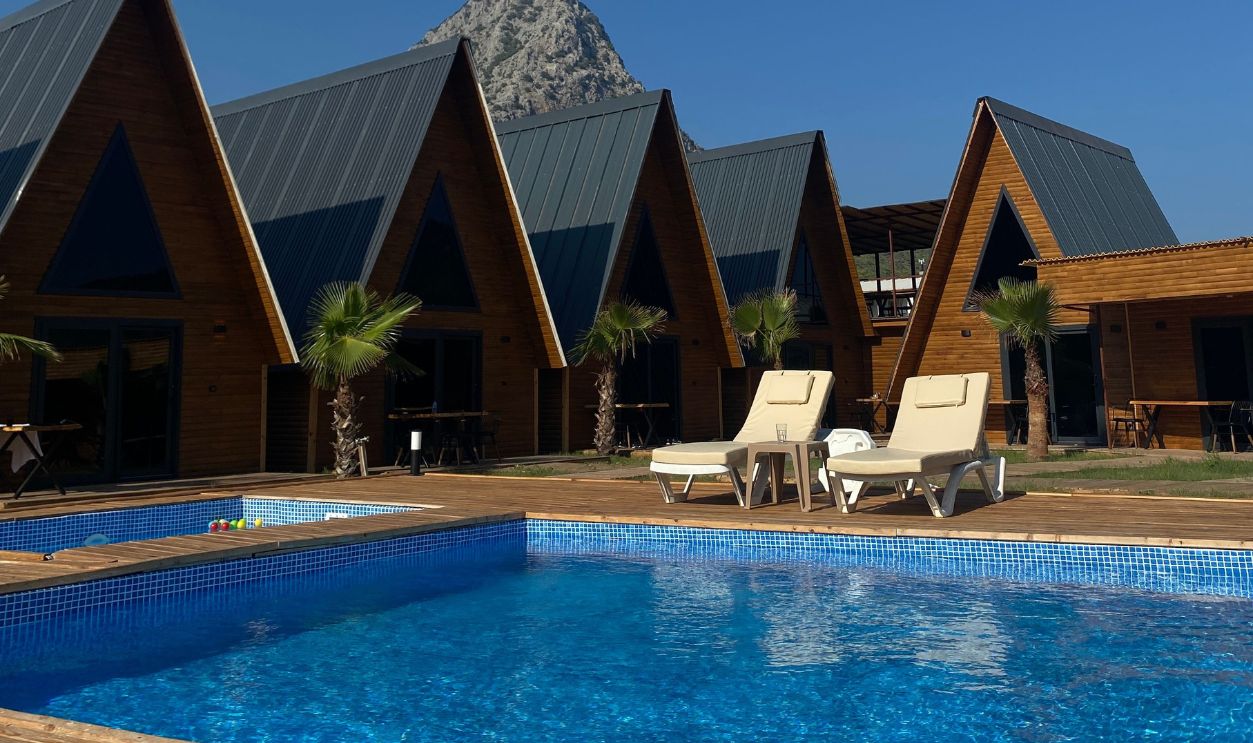 Sunlit vacation retreat in Adrasan with cozy cabins, pool, and mountain view for relaxation