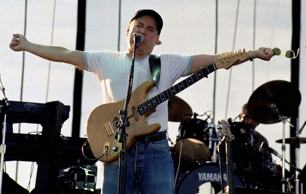 Singer and guitar player Paul Simon performs on stage