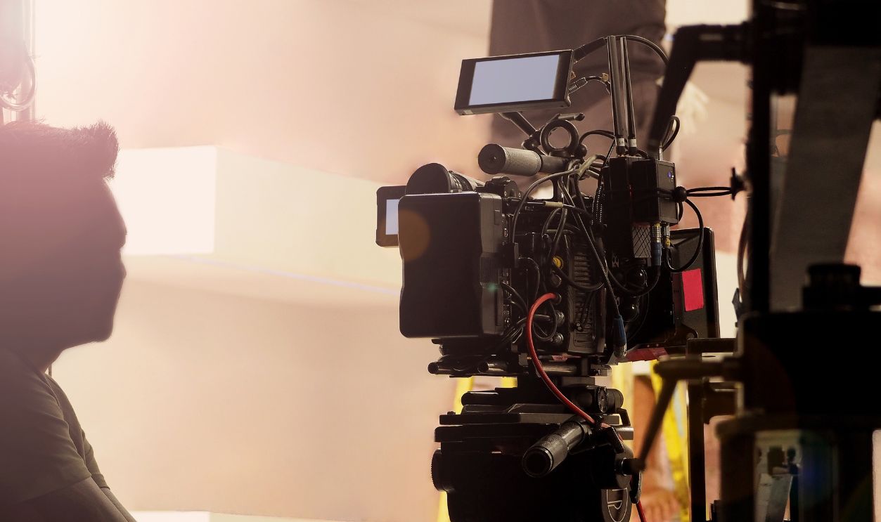 Filmmaker crew team with professional cinema equipment and video camera on the set. Film director and crew making commercial content advertising in studio. Technique of modern filming and advertising.