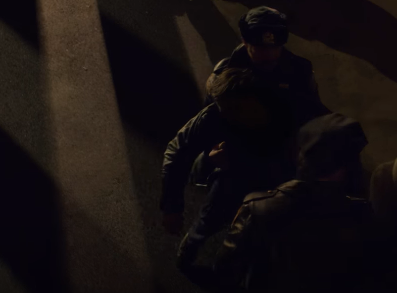 Screenshot of The Lennon Report (2016) showing police officers carrying John Lennon to hospital