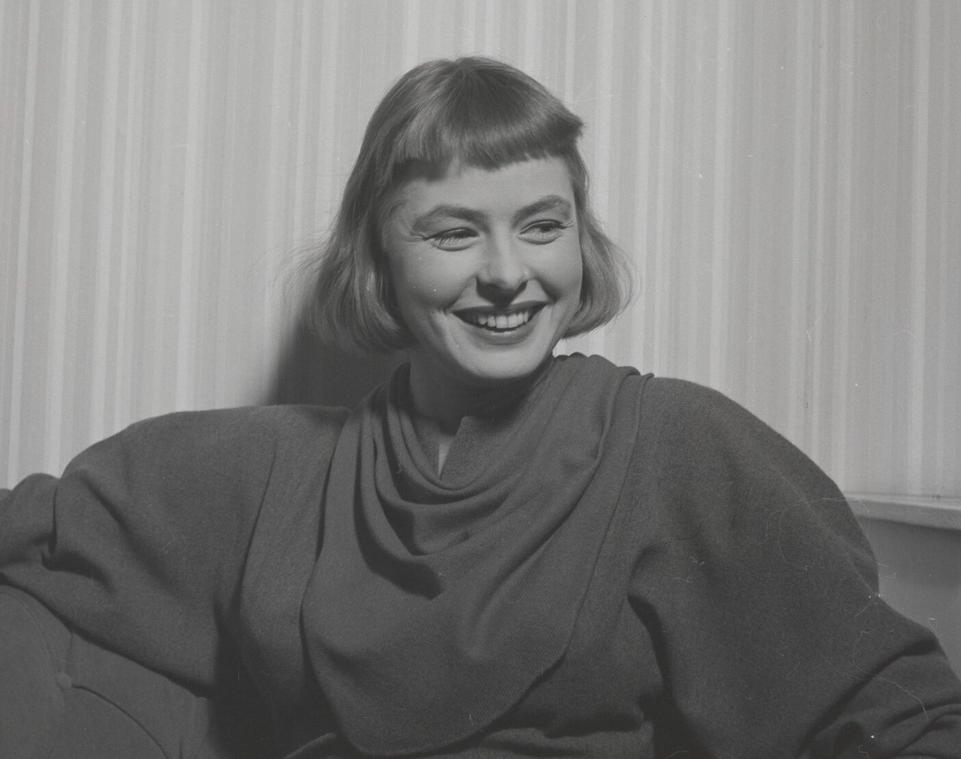 Grayscale Portrait Photo of Ingrid Bergman seated and smiling