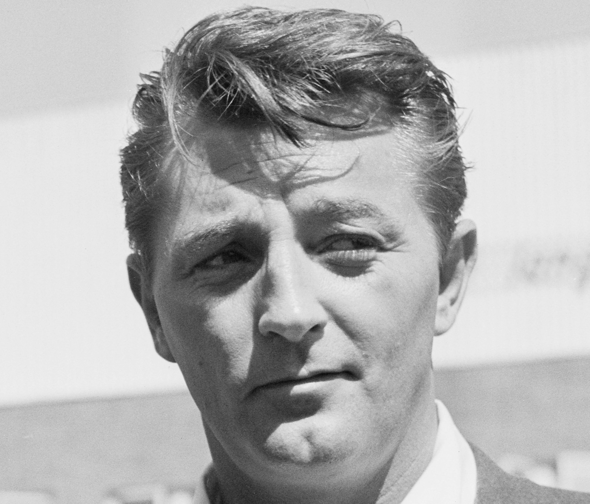 Grayscale Portrait Photo of Robert Mitchum wearing a gray suit