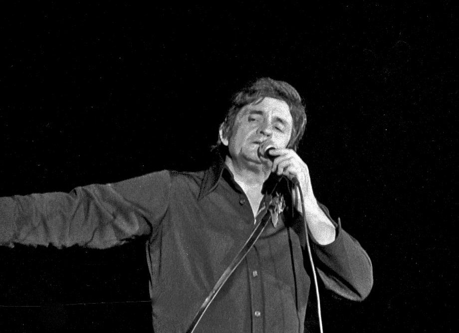 Grayscale Close Up Photo of Johnny Cash Performing on Stage