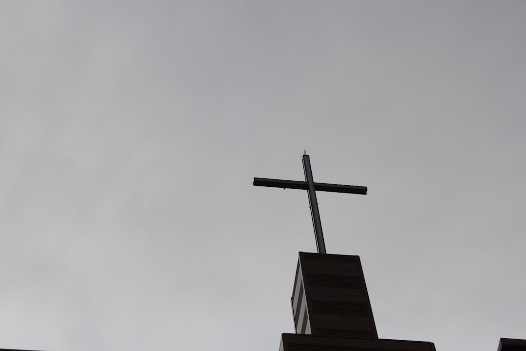 a cross on top of a building with a sky background