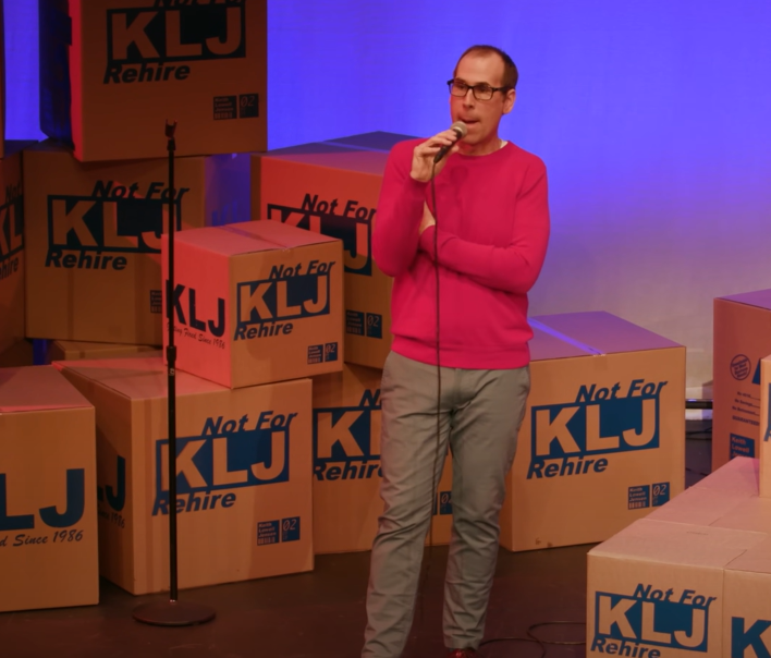 Keith Lowell Jensen in pink sweater performing