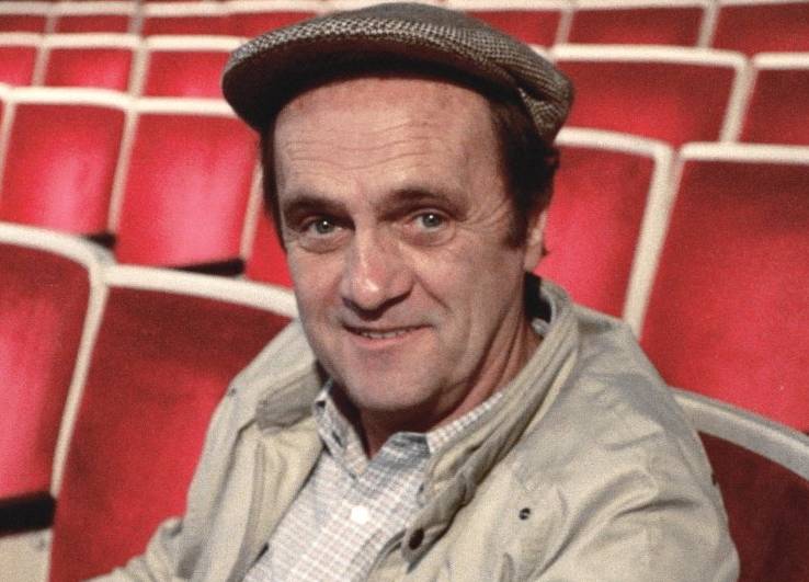 Bob Newhart in beige jacket and a hat