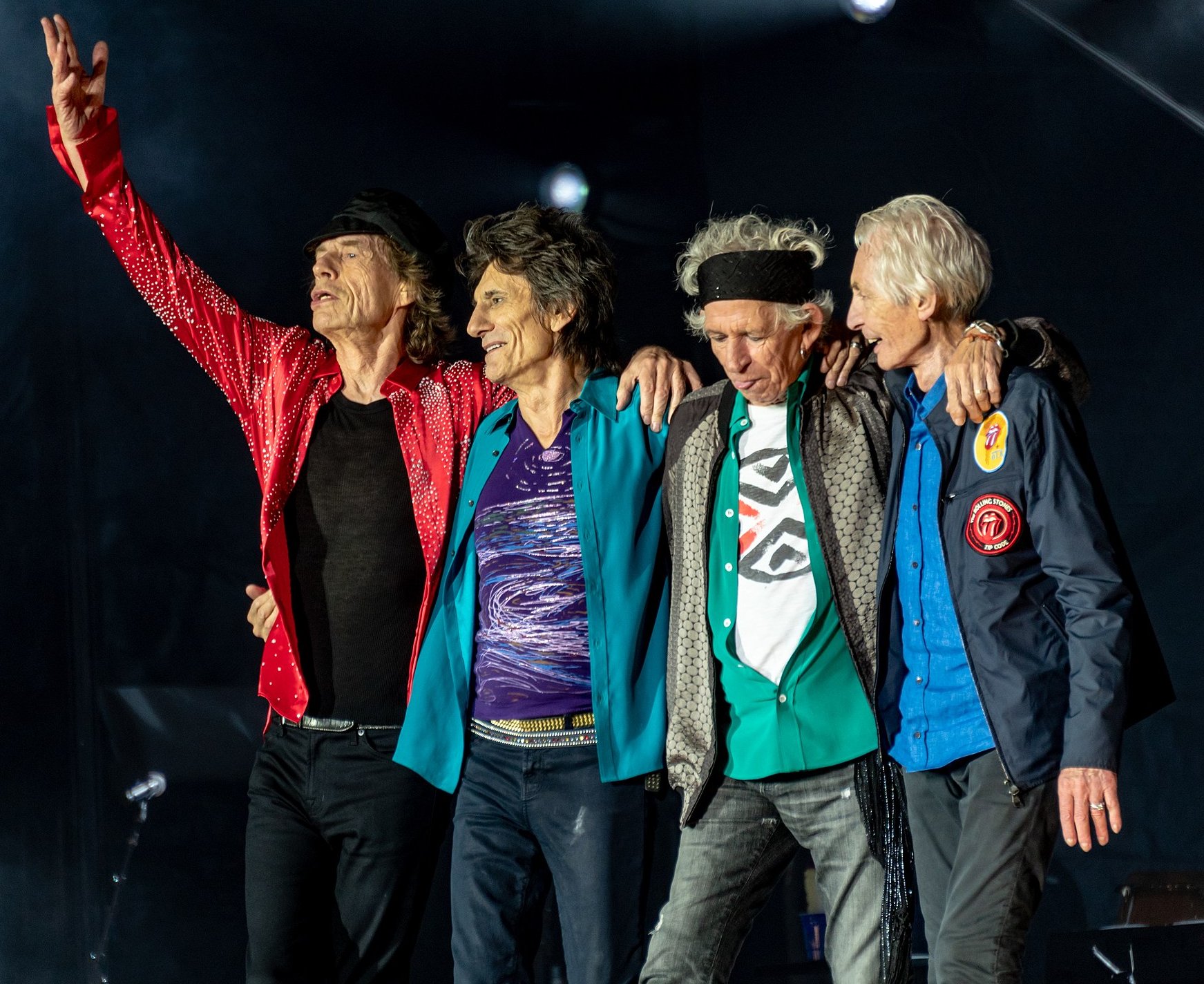 A portrait of The Rolling Stones performing live on stage, capturing the band members in action.