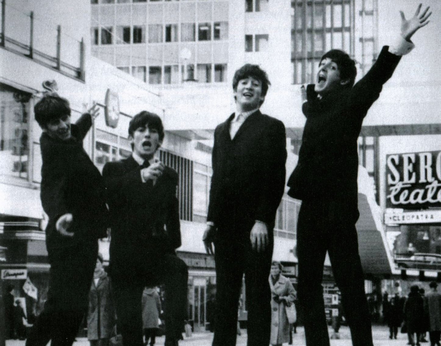 Members of the English Band The Beatles in dark suit jumping in the air