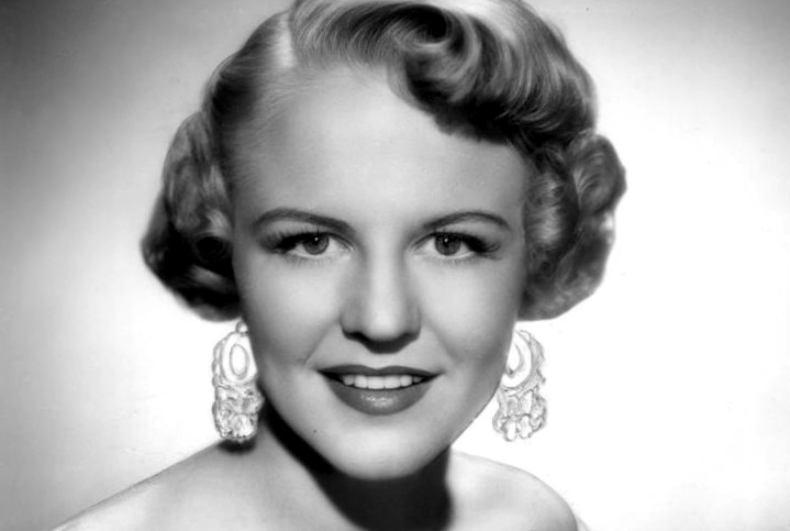 Peggy Lee in a white top and earrings