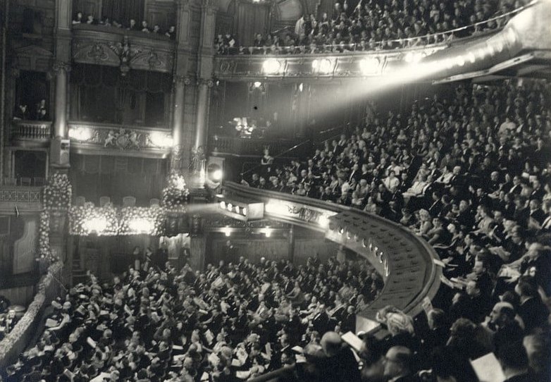 Grayscale Photo of Of The London Palladium Filled To Capacity