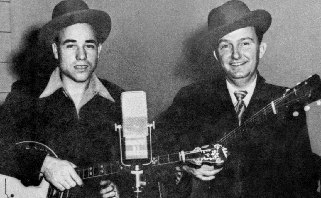 Earl Scruggs and Lester Flatt holding instruments