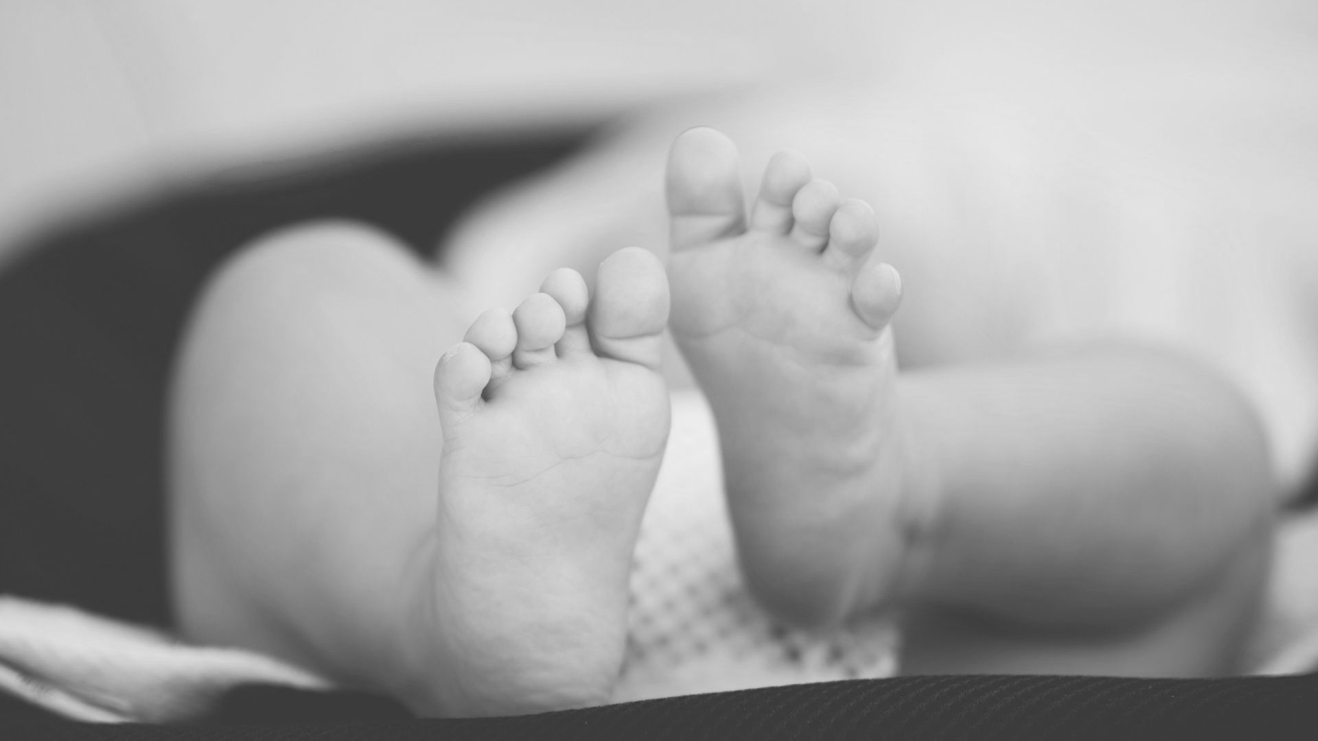 shallow focus photography of baby wearing white diaper lying