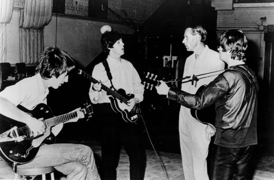 Publicity photo of the Beatles with producer George Martin in the studio at Abbey Road.