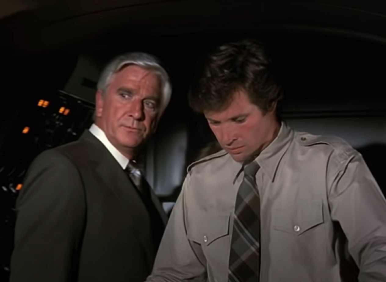 Screenshot of Leslie Nielsen and Robert Hays talking - from Airplane! (1980)