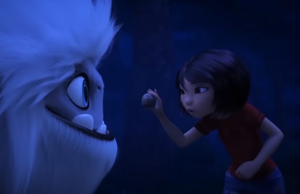 Girl holding ball in front of big monster