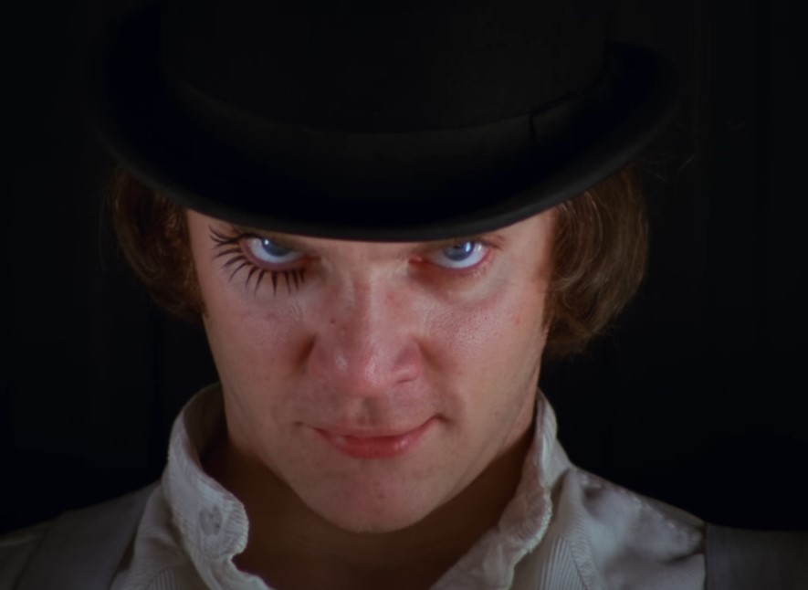 Man looking into the camera from below the hat