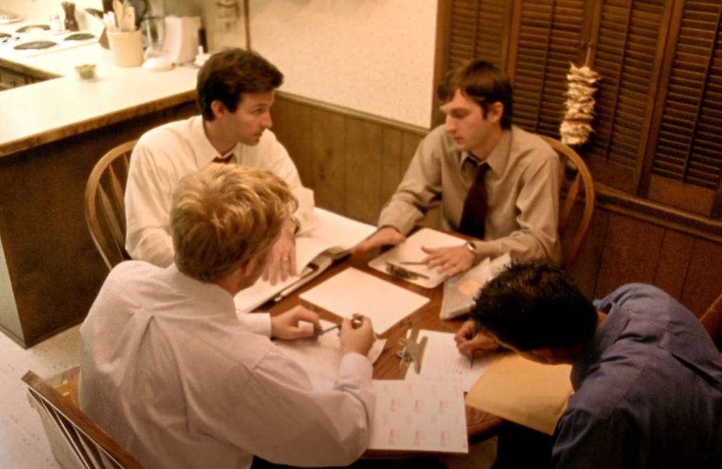 Actors in  Primer (2004) sitting at a table