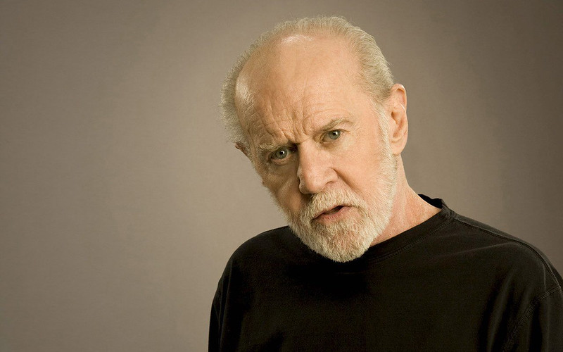 Portrait Photo of the comedian George Carlin in a black shirt