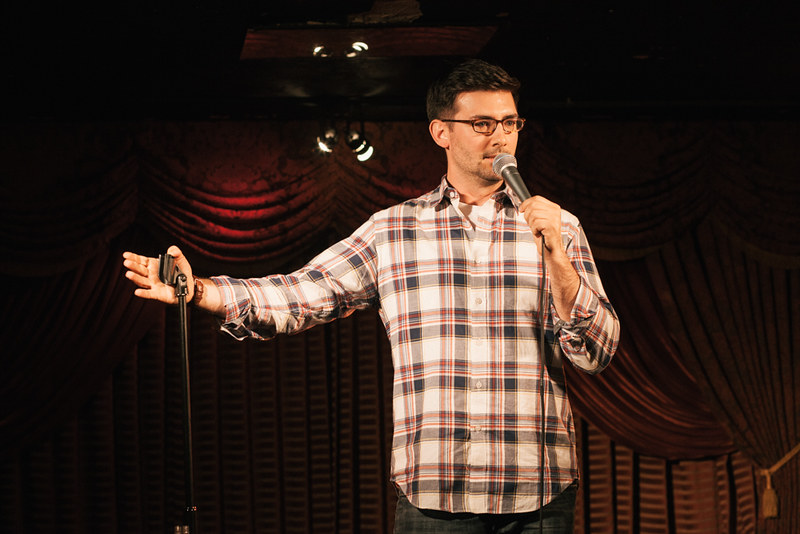Portrait Photo of comedian Tommy Johnagin performing on a stage