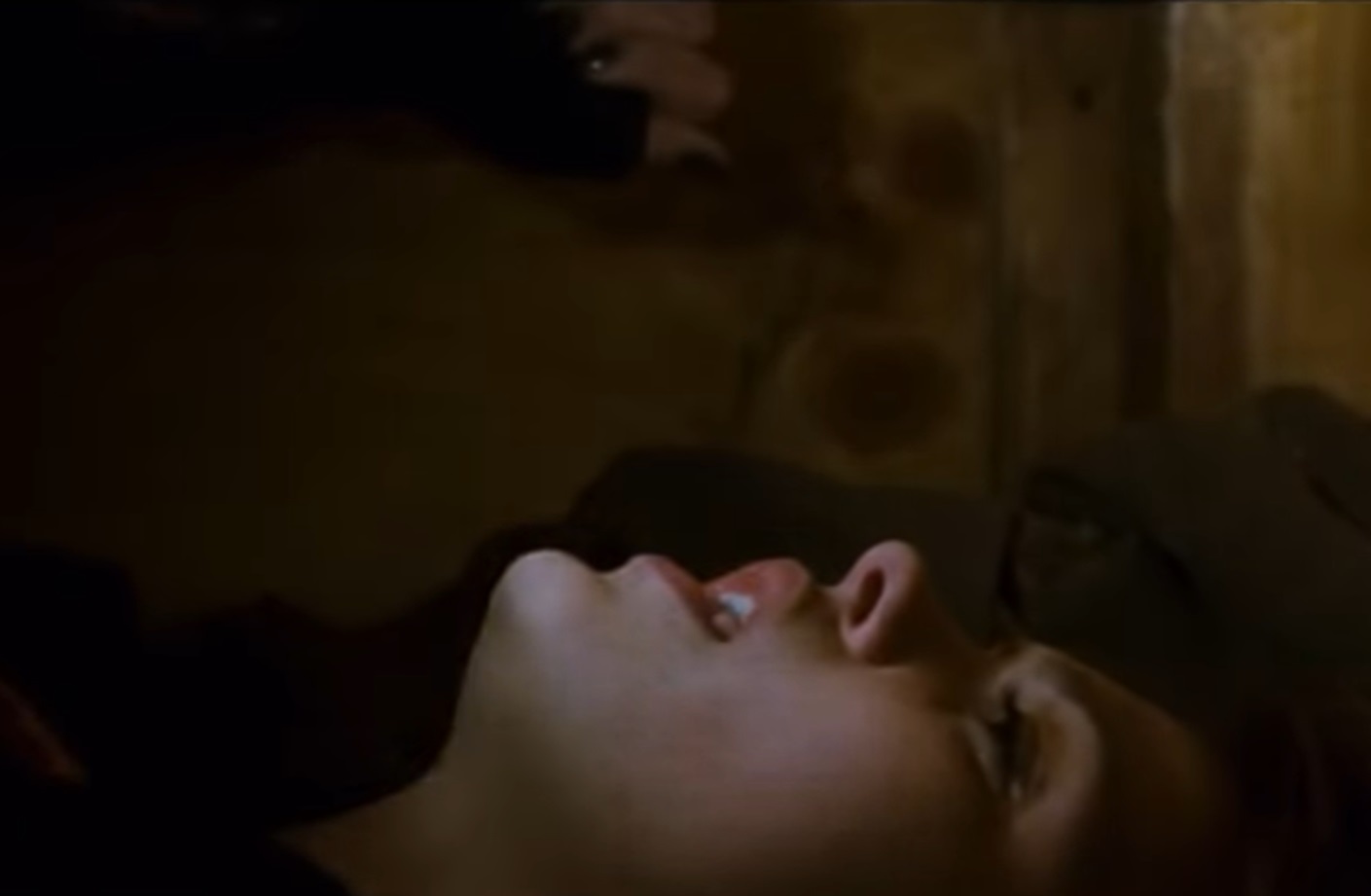 Screenshot of Aimee Teegarden laying in dark from - Beneath the Darkness (2011)