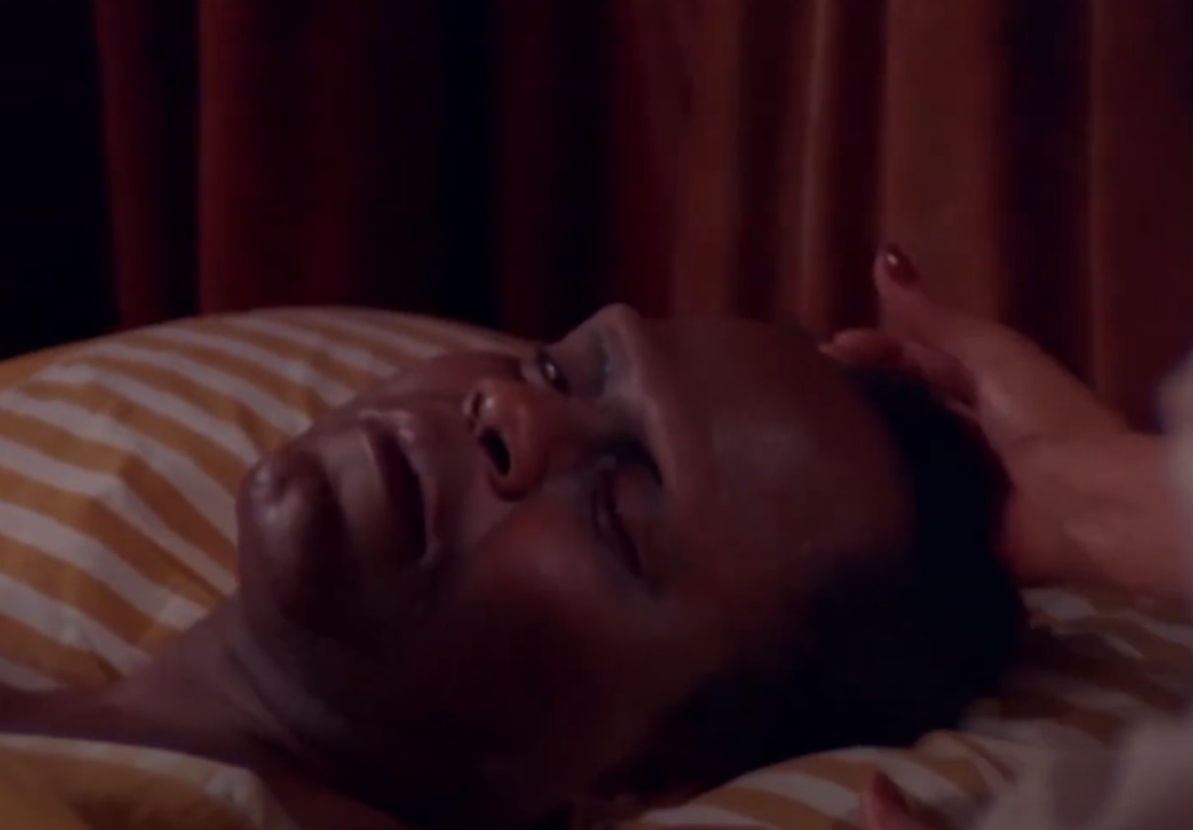 Screenshot of Joe De Sue laying on the bed from - Blackenstein (1973)