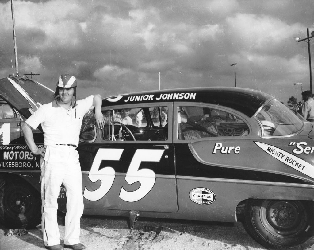 Junior Johnson poses next to his NASCAR Cup Oldsmobile