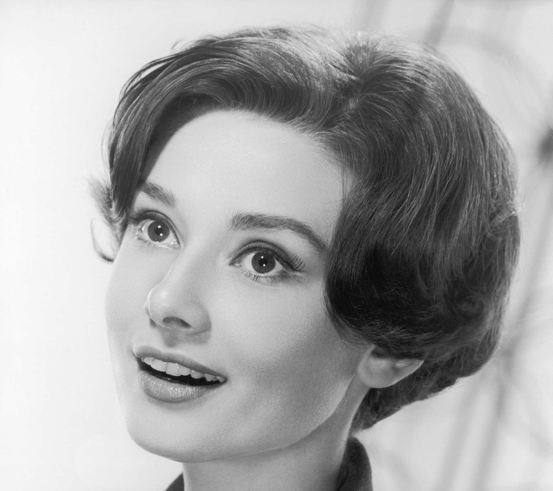 Grayscale Photo of actress Audrey Hepburn, smiling, looking upwards