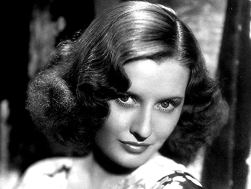 Grayscale Portrait Photo of Barbara Stanwyck n a floral dress, facing the camera