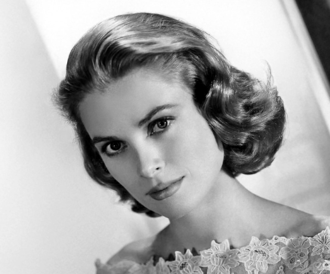 Grayscale Portrait Photo of Grace Kelly in floral dress, facing the camera.