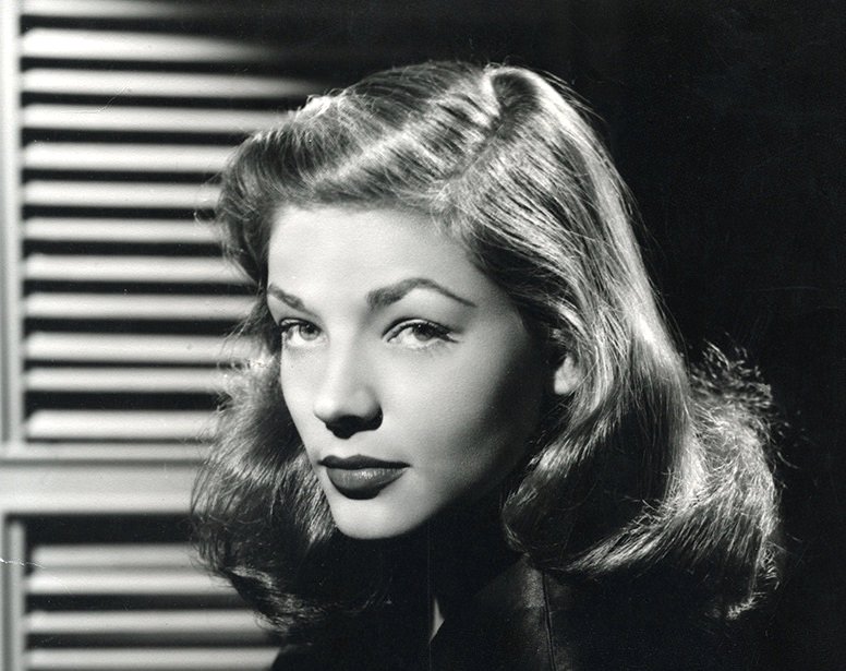 Grayscale Portrait Photo of Lauren Bacall in a black dress facing the camera