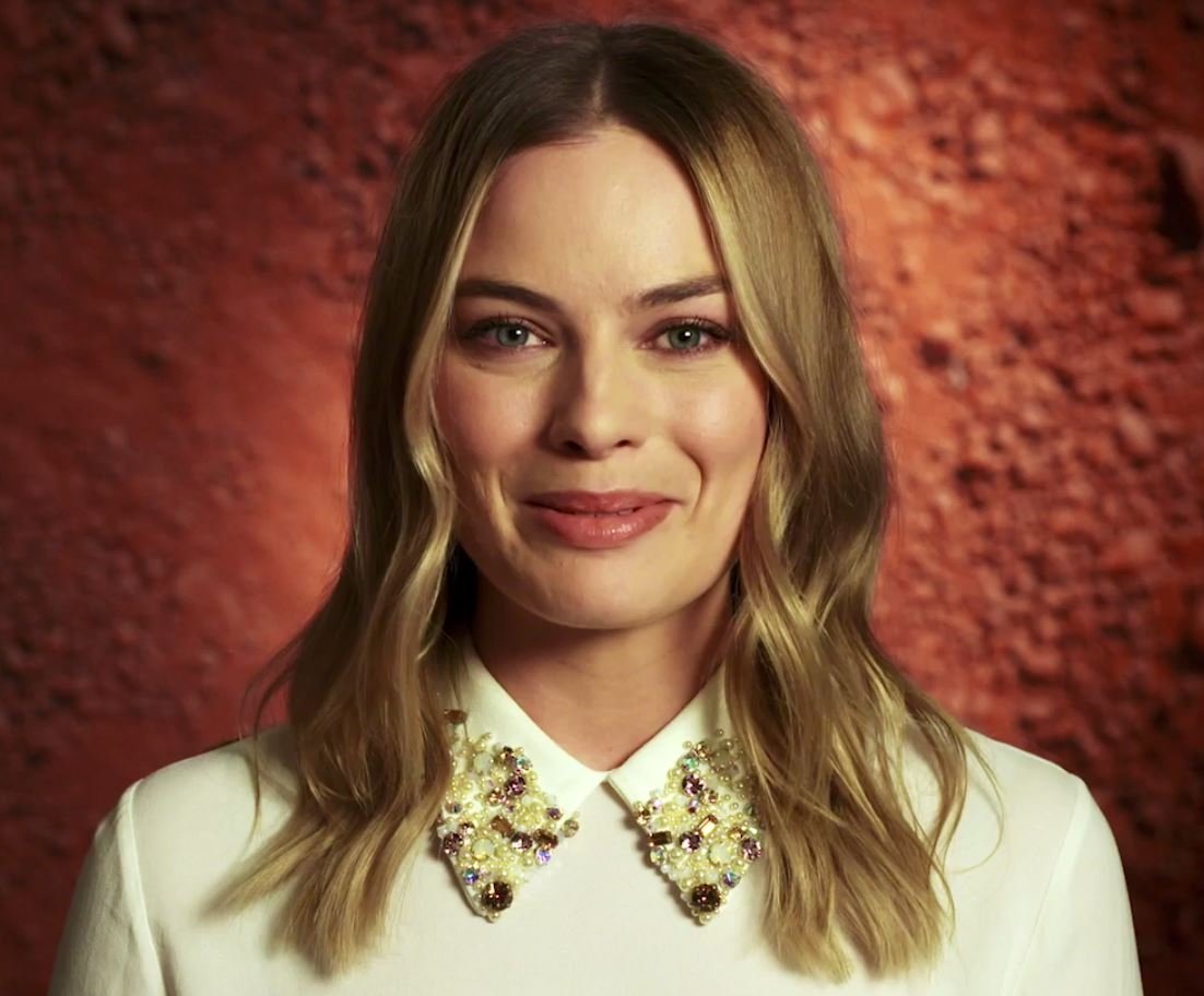 Portrait Photo of Margot Robbie talking to camera about Oxfam's 