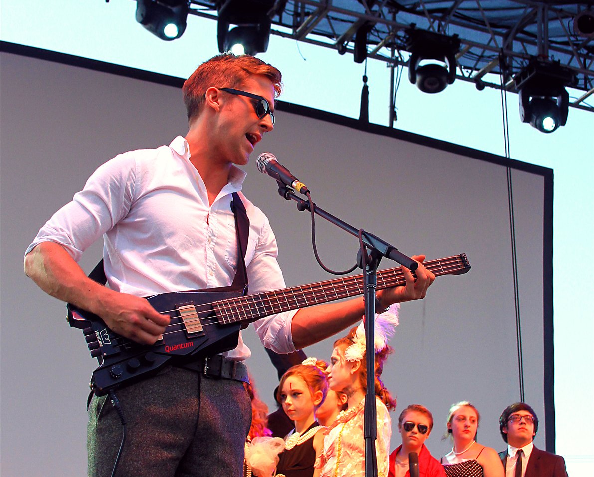 Portrait Photo of the Actor Ryan Gosling performing on a stage with his guitar