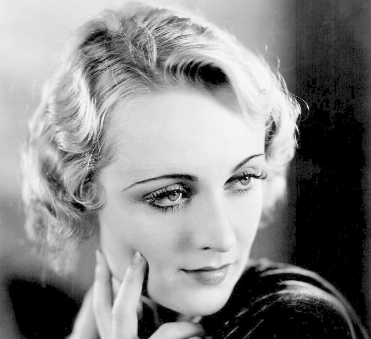 Grayscale Publicity photo of Carole Lombard in a dark outfit
